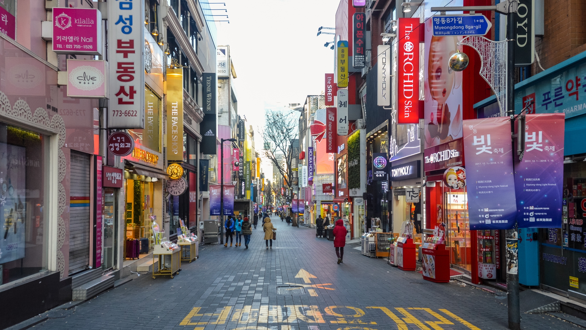 A busy Seoul shopping street lined with Korean signs